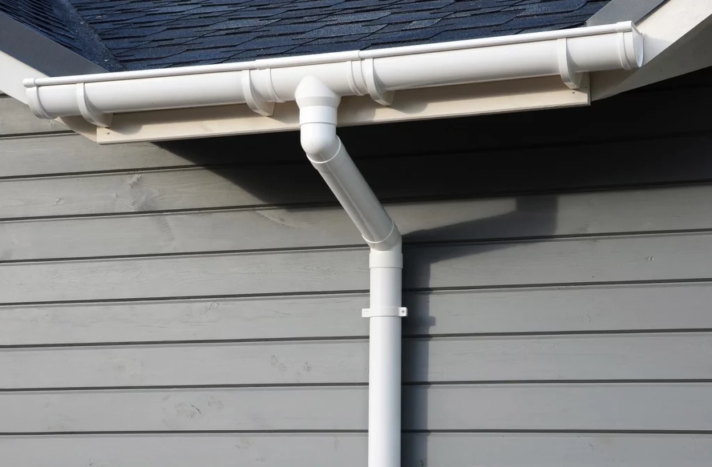 rain gutter system installed on gray vinyl siding house