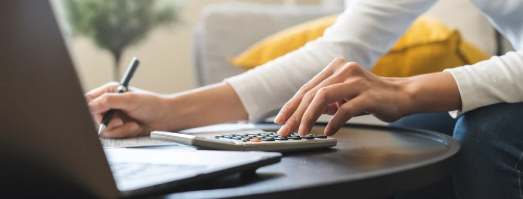 woman calculating roof replacement cost on laptop