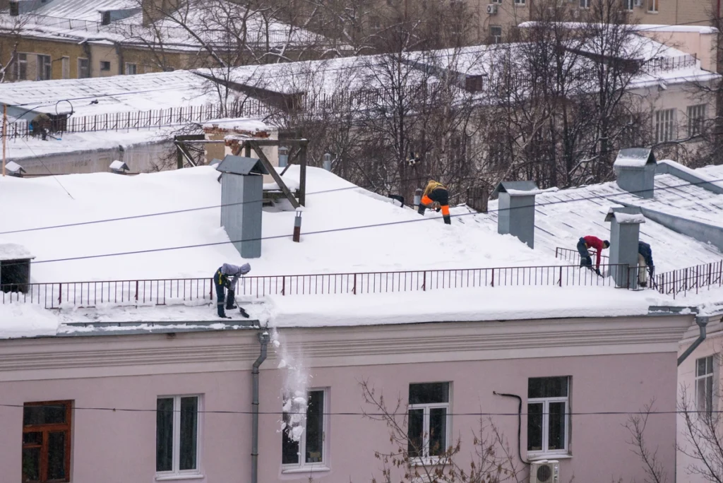 contractors shoveling snow off roof and performing ice dam removal