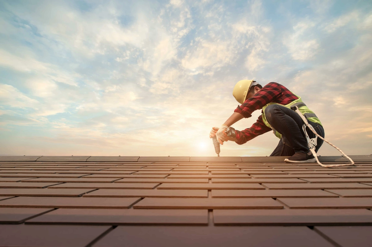 A roofer working at sunset