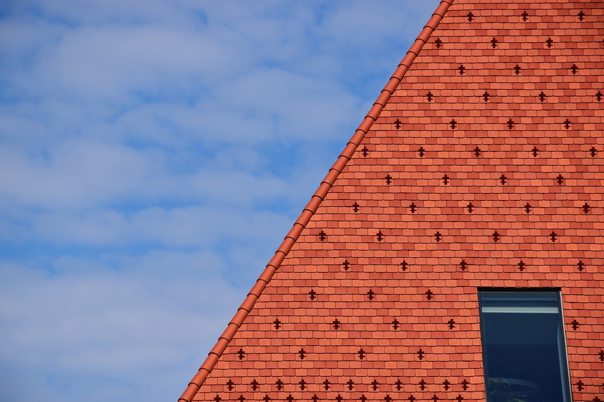a steep tile roof against the blue sky
