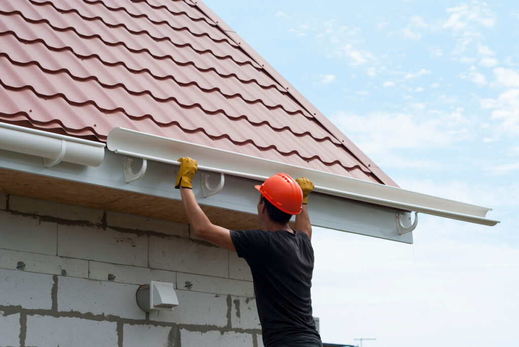 a worker is installing a gutter