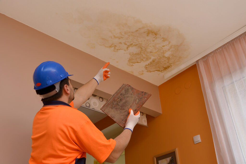 a worker is inspecting water leakage damp on ceiling