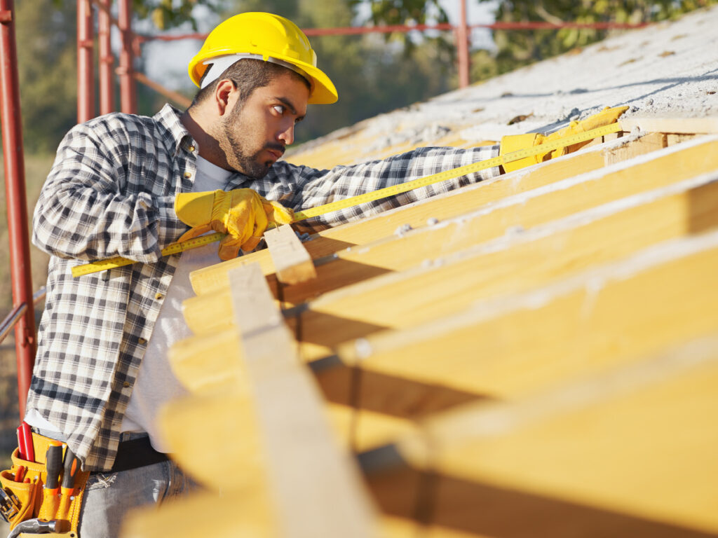 a person measuring roof for installing roof pitch