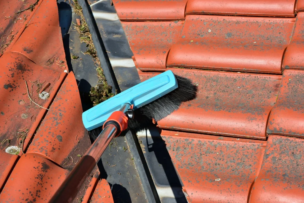 scrubbing debris from roof flashing during roof moss removal