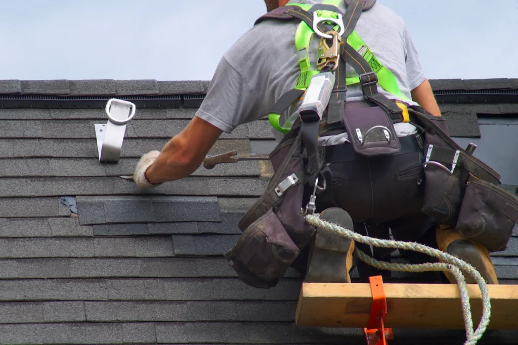 man on roof wearing safety harness