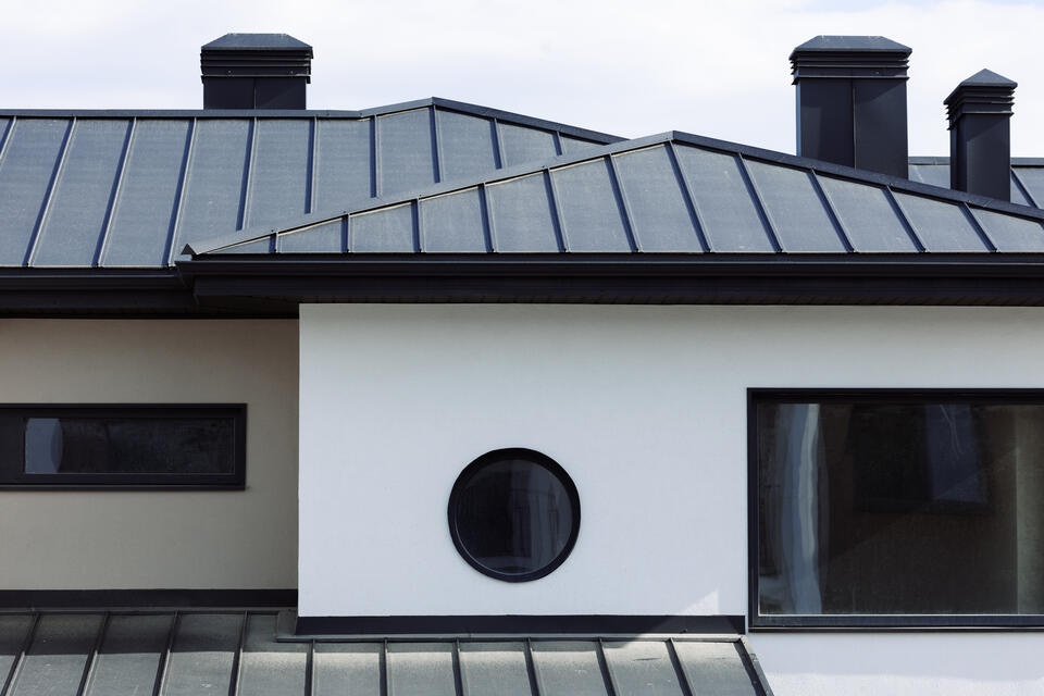 standing seam metal roof-black standing seam roofing on white sided house