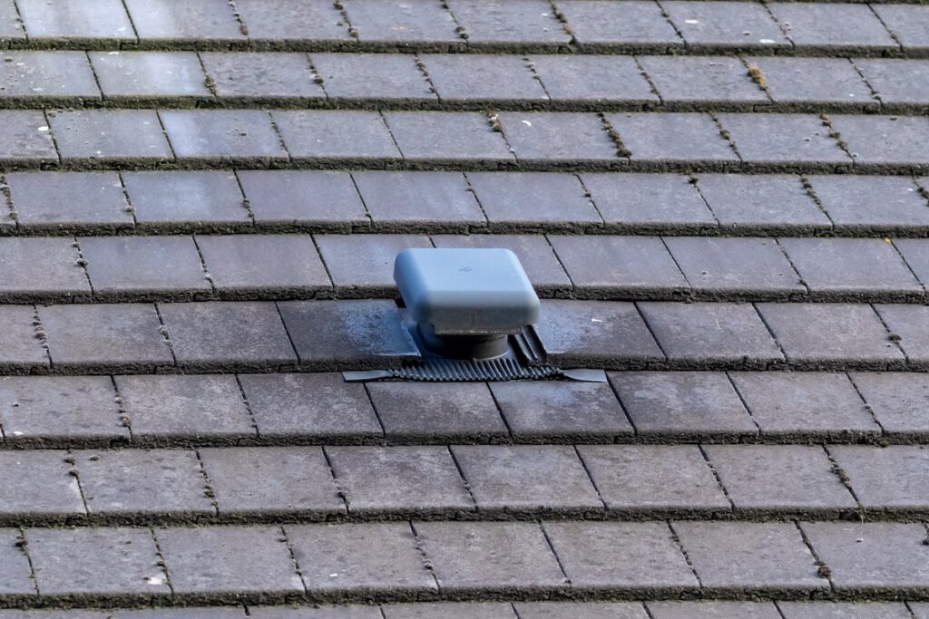 Damaged slate roofing around roof vent