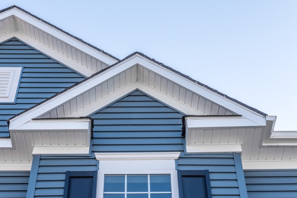 Blue vinyl siding with white trim and roof line