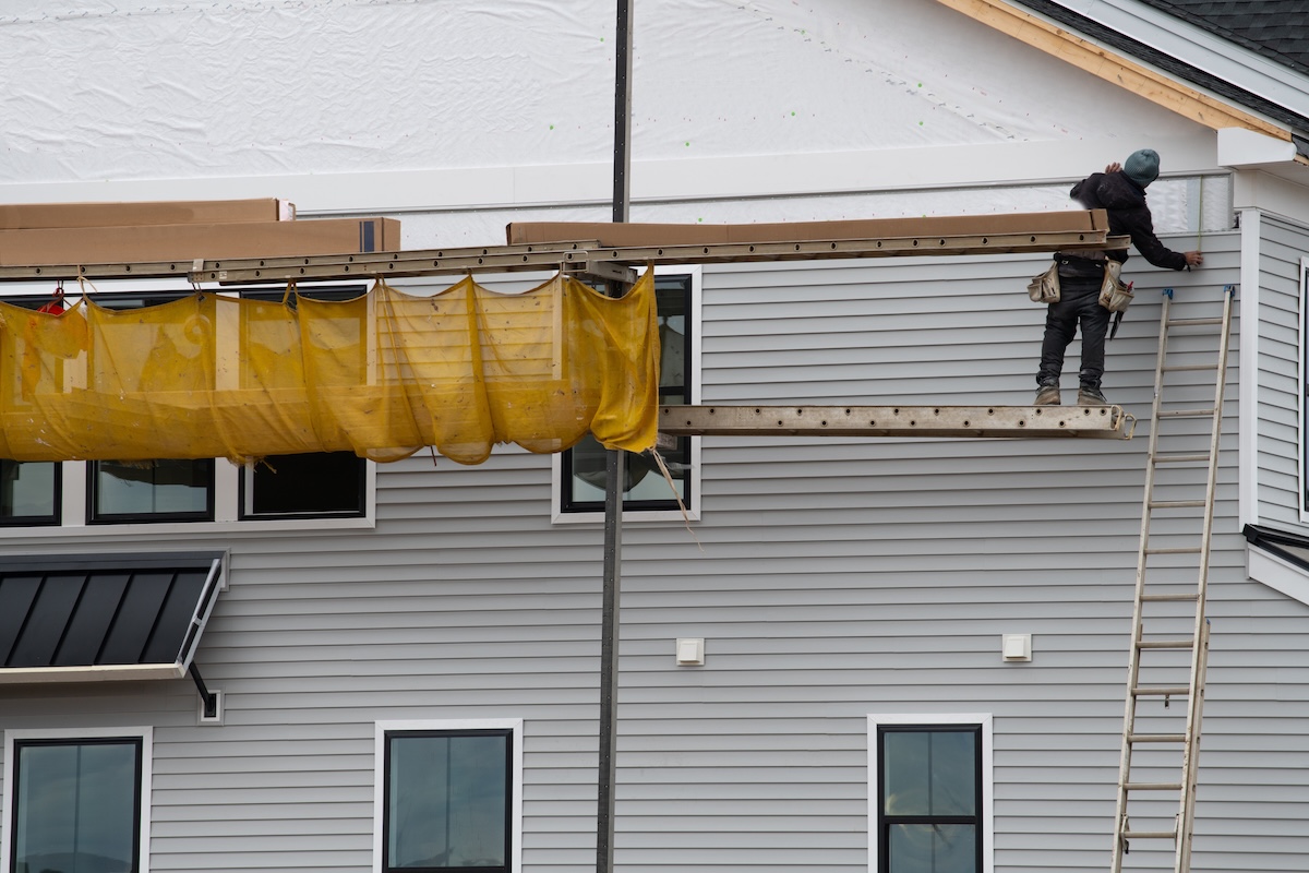 covering a new house with siding facade plastic wall