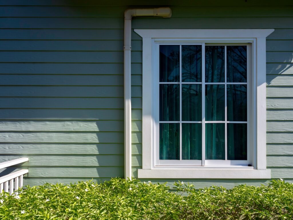 Green house with white window trim exterior