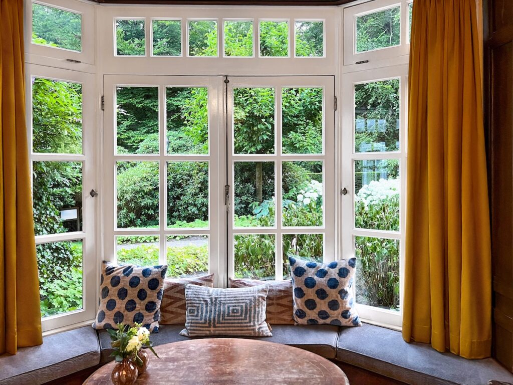 Indoors view of bay window with table and yellow curtains