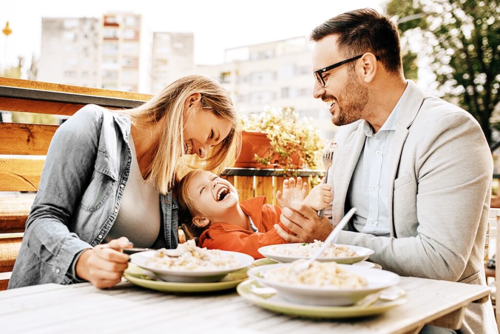 Happy family is enjoying pasta in restaurant