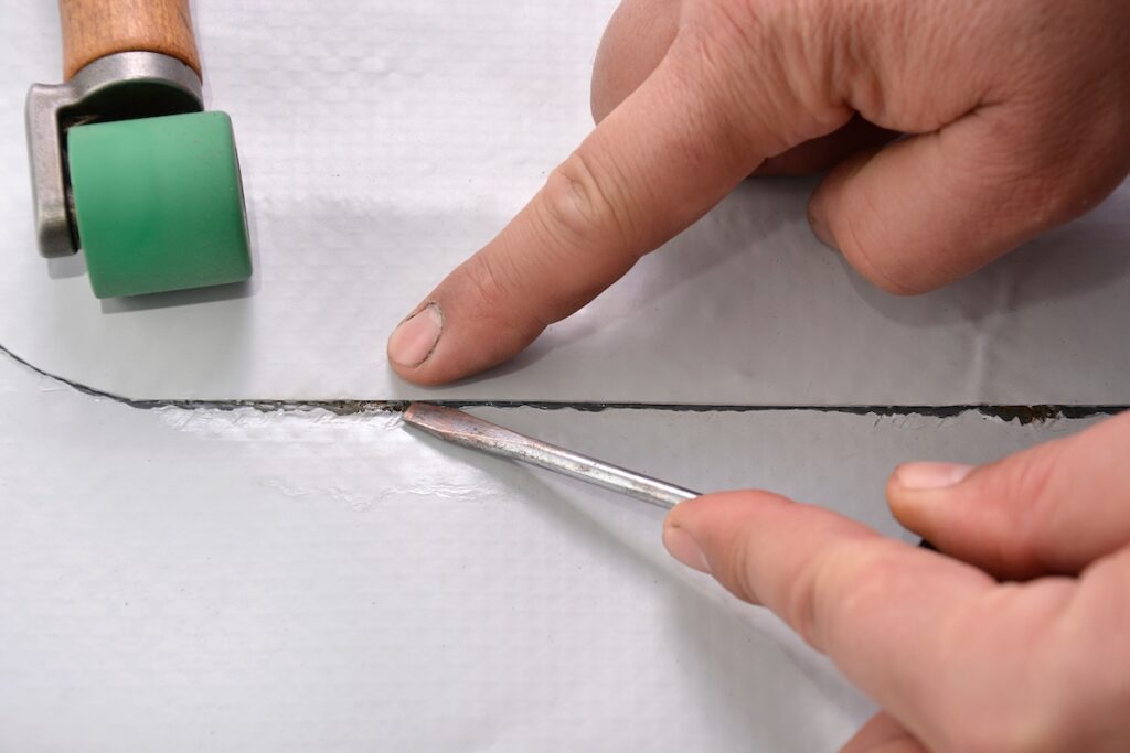 Roofer repairing TPO roofing material close-up