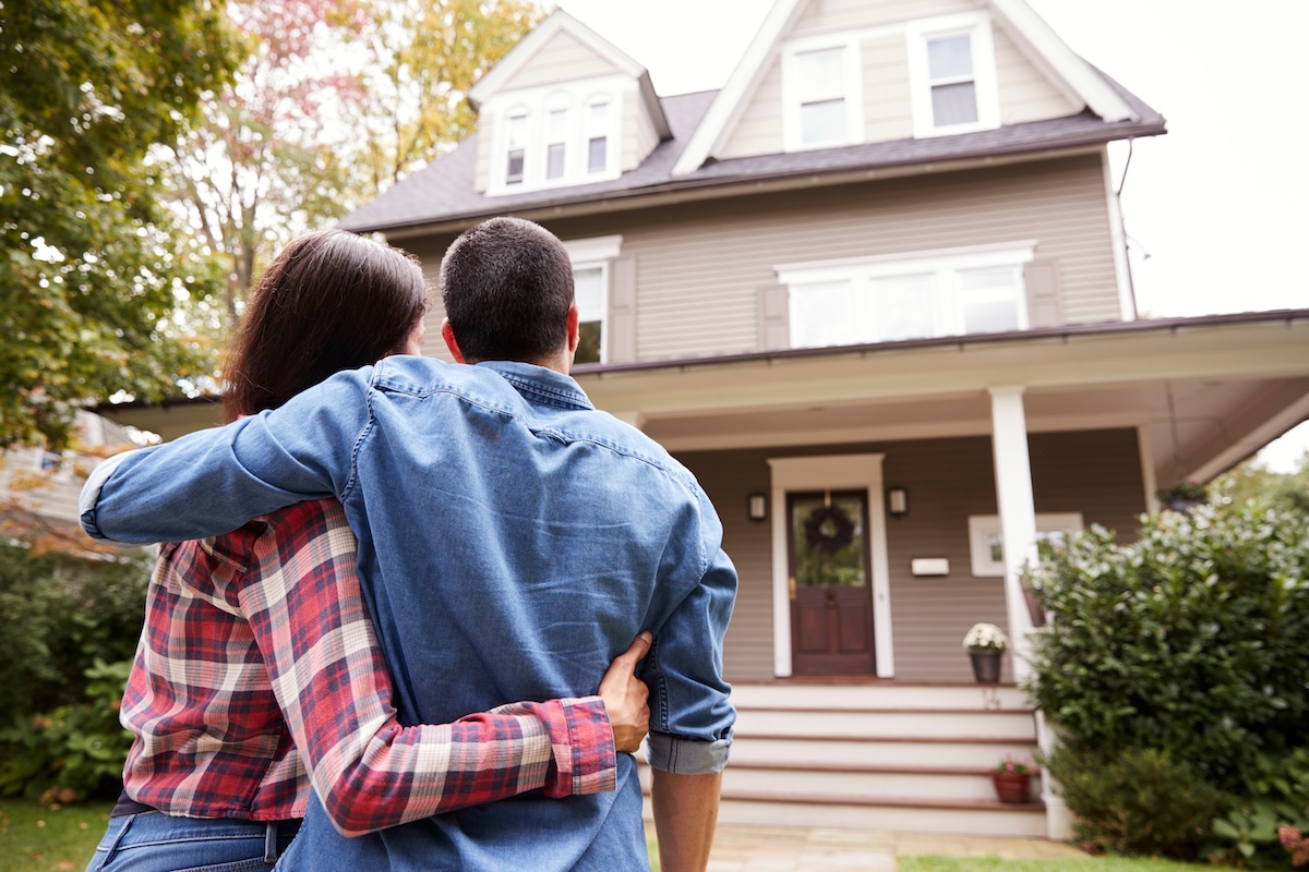 Rear View Of Happy Couple Looking At House