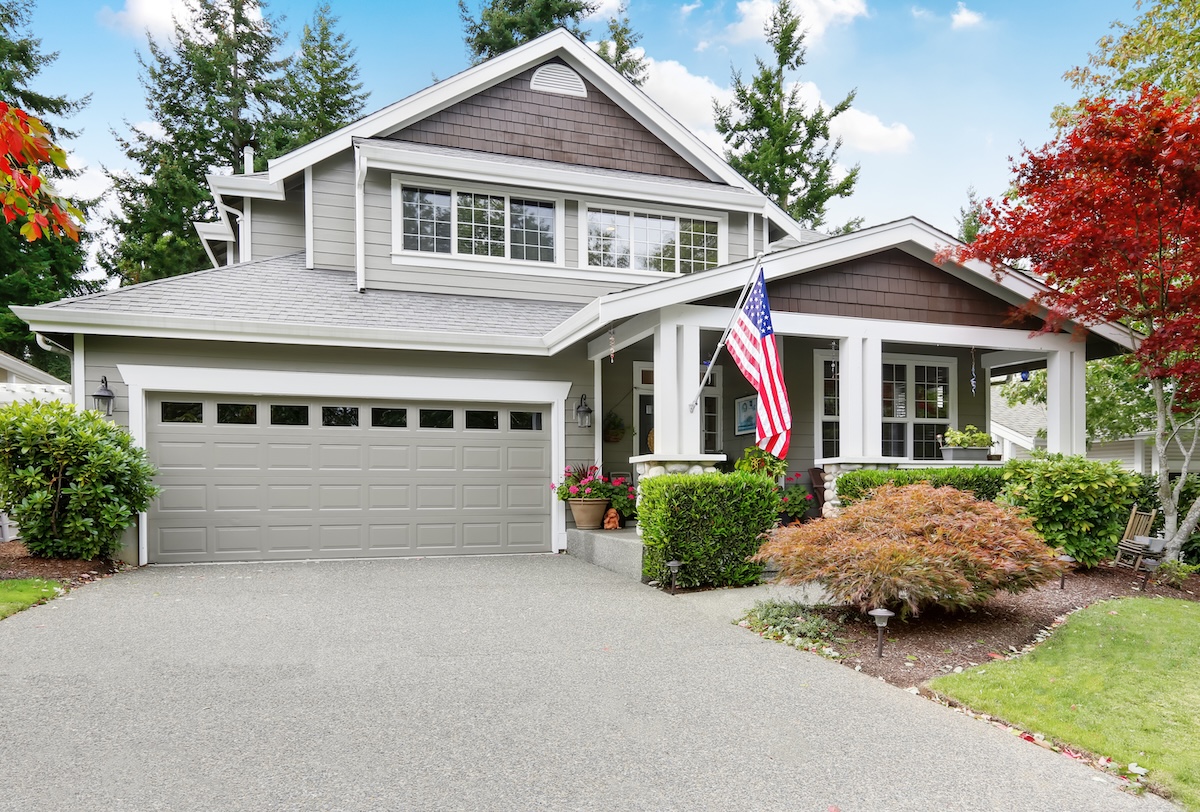 Nice curb appeal of grey house with garage and driveway. 