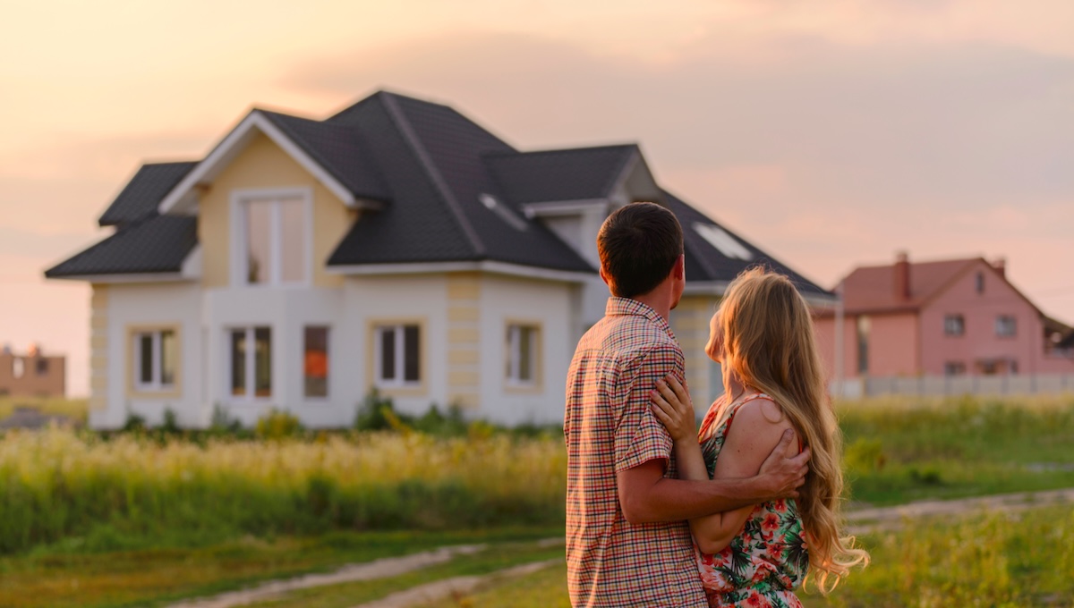 Couple hugging and looking at their newly renovated house