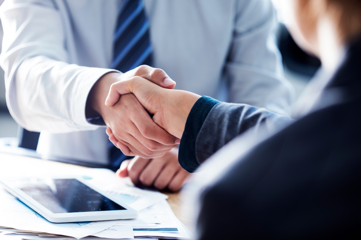 business handshake across desk