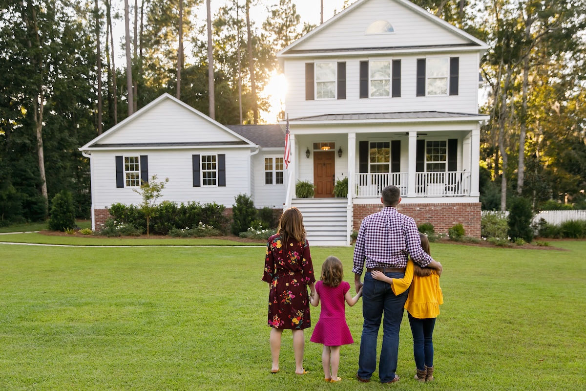 family of four looking at house