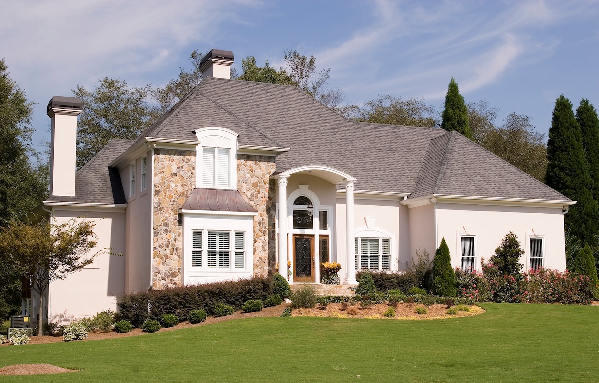 A nice stone and stucco house on a grassy hill