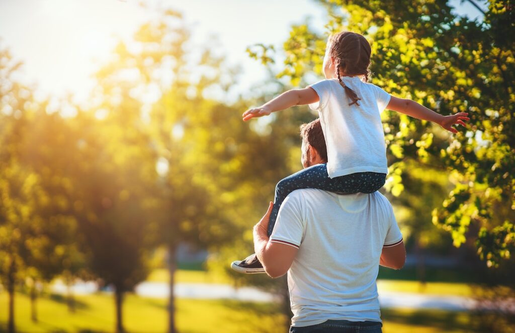 child riding on dads shoulders