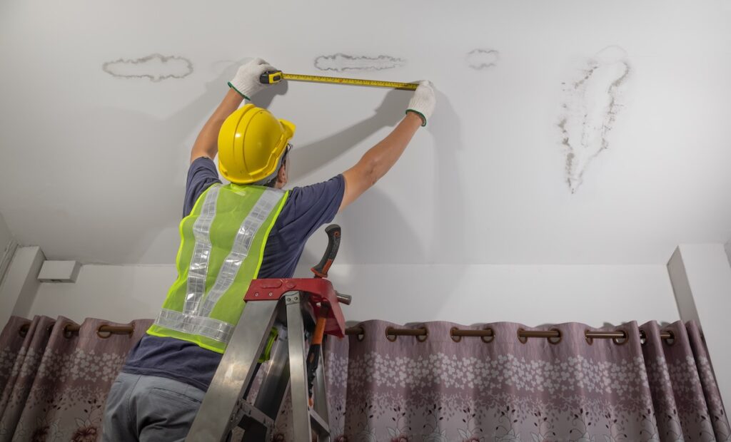 Worker fix leaking ceiling ,close-up of a stain on the ceiling.