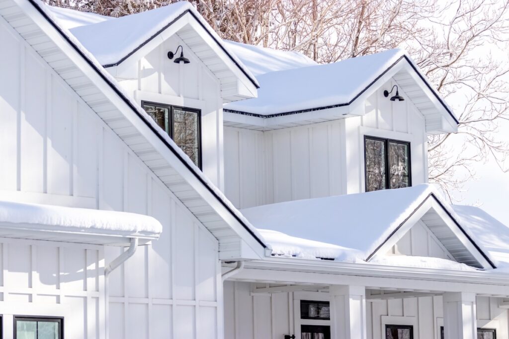 A modern farmhouse covered in a fresh layer of winter snow.