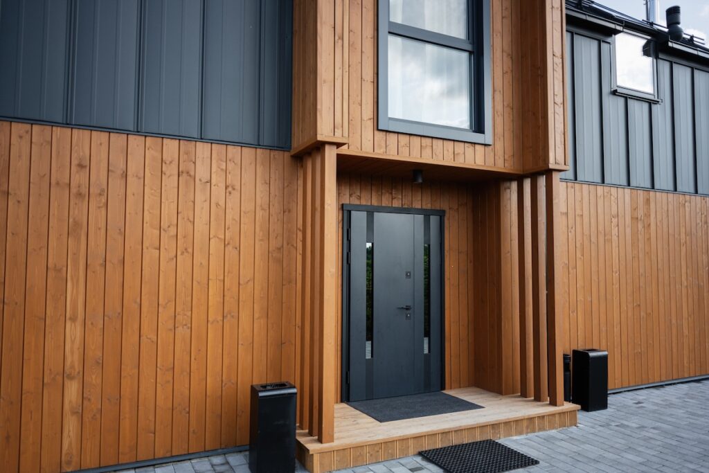 Entrance of a contemporary wooden house with sleek door and vertical paneling