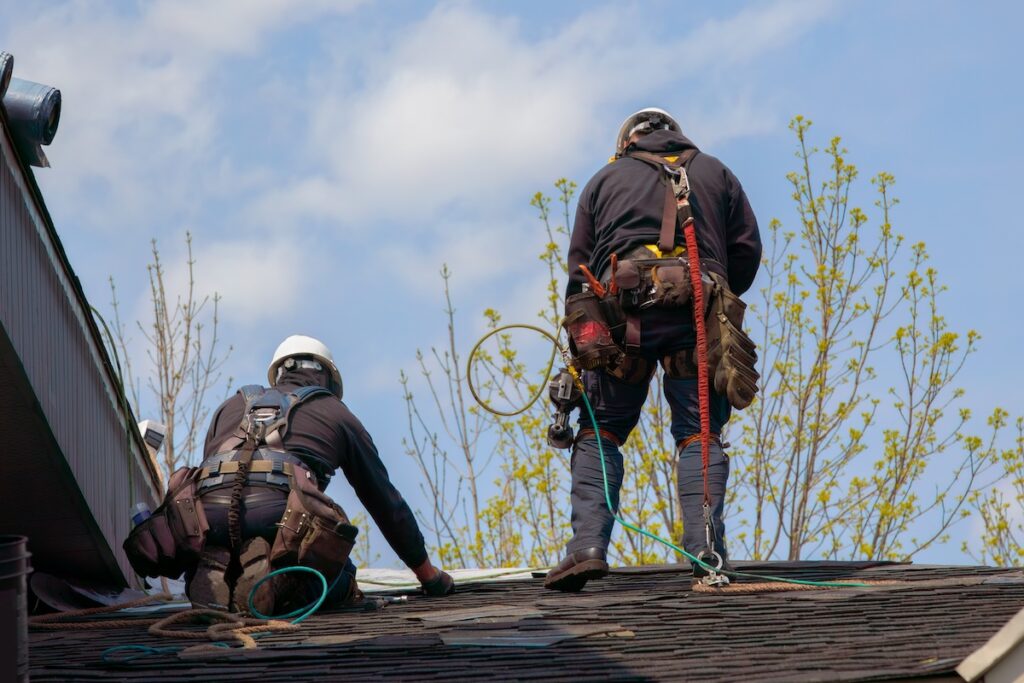 roof repair construction worker two roofers mans roofing security rope