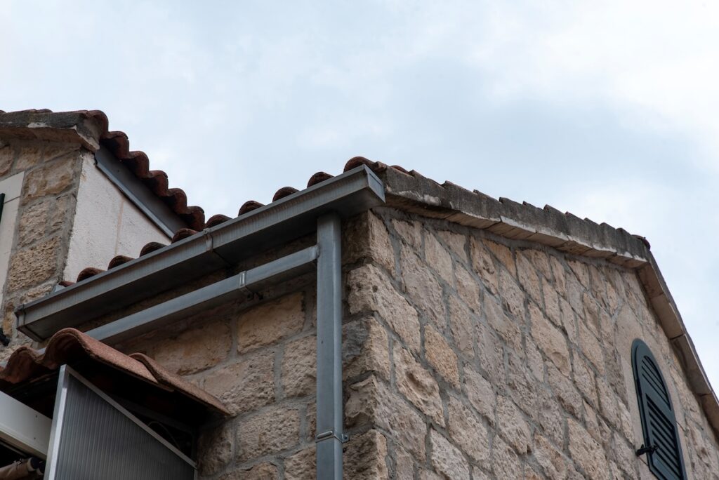 Metal square gutter and downpipe on eaves