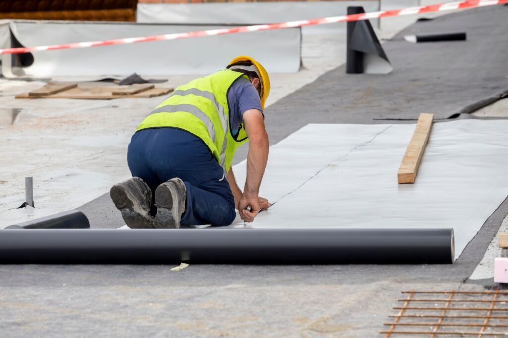 construction worker installing pvc roofing