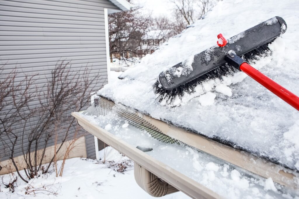 Gutters with ice dam and broom for raking snow off of roof