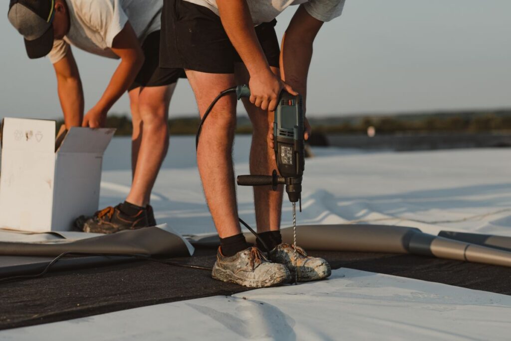 commercial roof leak repair workers intalling TPO membrane