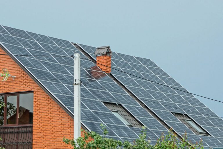 solar shingles vs solar panels big roof covered with panels orange brick wall