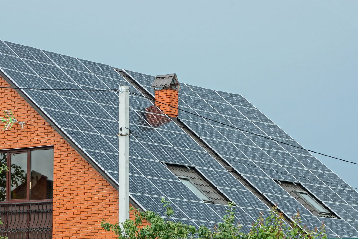 solar shingles vs solar panels big roof covered with panels orange brick wall