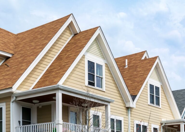 pitched roof brown shingles light yellow sliding white frame windows
