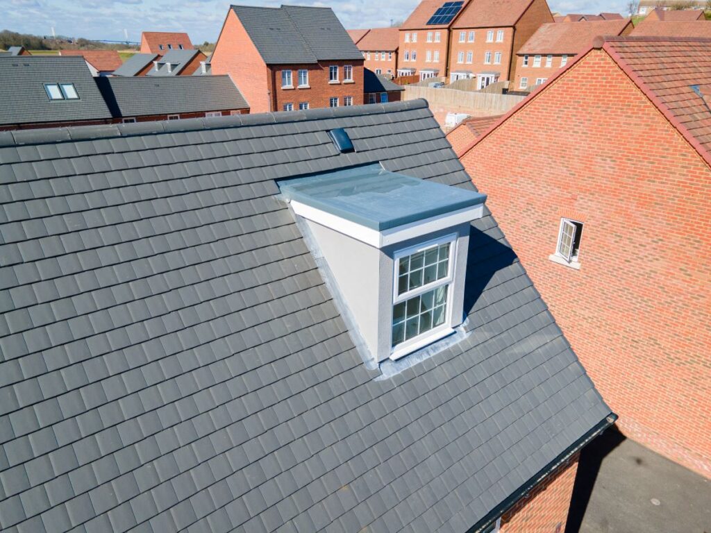 pitched roof grey slate shingles orange brick wall