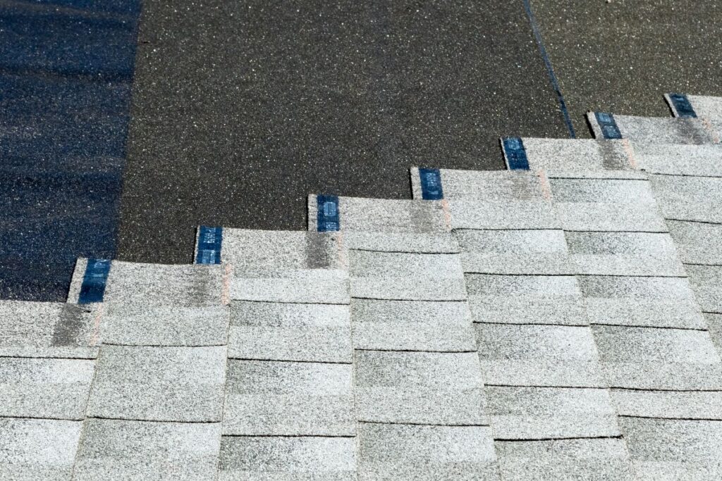 asphalt shingles being installed on top of roof underlayment