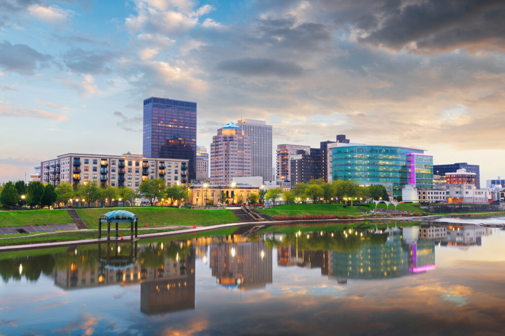 things to do in dayton ohio Dayton, Ohio, USA downtown cityscape on the Miami River at dusk.
