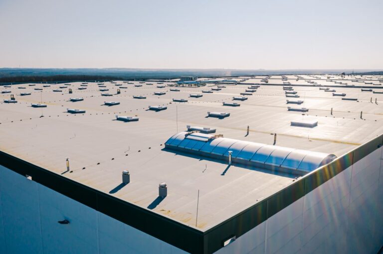 Large roof of factory with roof ventilators, drone shot from above