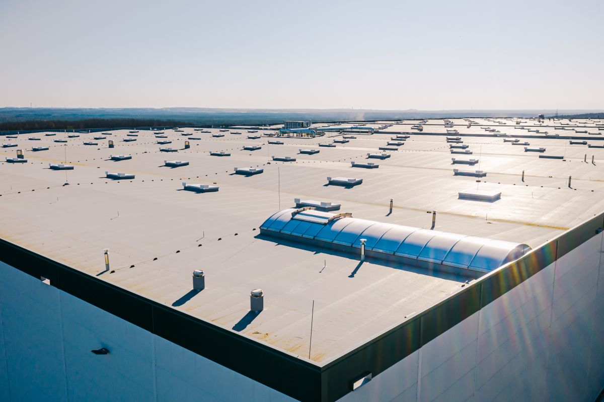 Large roof of factory with roof ventilators, drone shot from above
