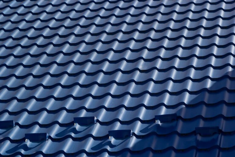 The roof of a house covered with sheets of blue metal tiles