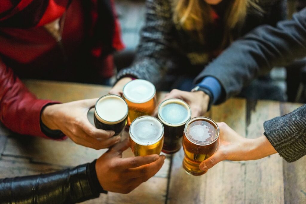 Young group of people having fun cheering with beer