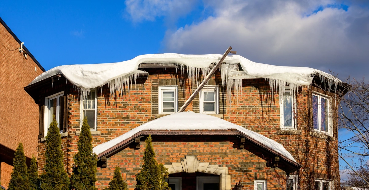Ice dam buildup along the roof edge of an older house