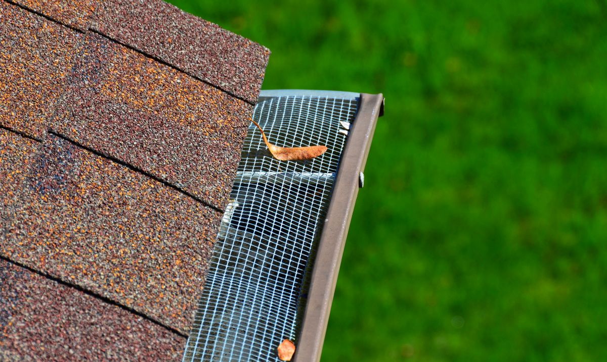 Closeup of a metal filter on a gutter. A leaf on the filter.